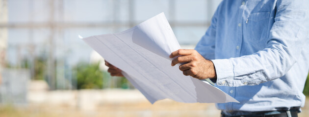 Engineer checking blueprint for property construction.