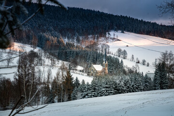 Landschaft mit Kirche in Ortschaft im Winter