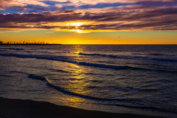 Incredibly beautiful best orange sunrise on the Mediterranean Sea in Sitges. Sea, sky with clouds, birds and horizon