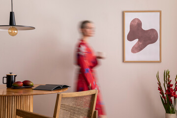 Sunny and bright space of living room with mock up poster frame, woman in red kimono, bouquet...