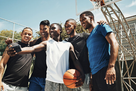 Selfie, basketball and team on a sports court for partnership, collaboration and training together with a phone. Happy, young and athlete group with a photo on smartphone while doing fitness exercise