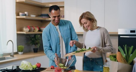 Multiethnic couple in the kitchen preparing the healthy breakfast in the morning they cooking together. Healthy lifestyle and enjoying quality leisure time at home. - Powered by Adobe