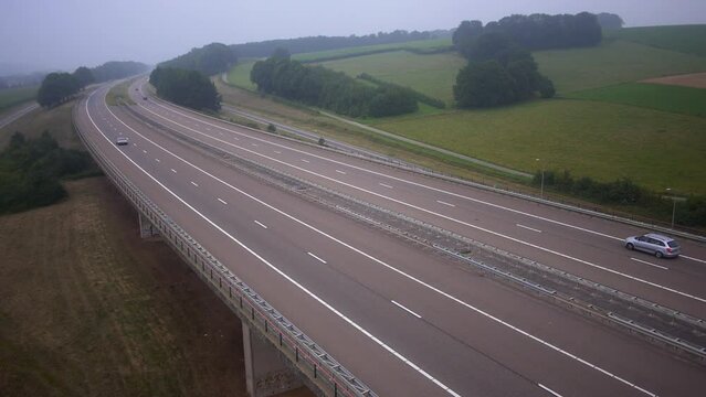 DMC DeLorean driving on Highway in hilly landscape, seen from above.