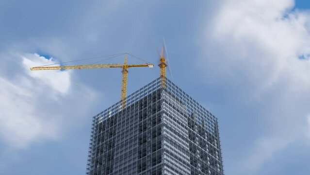 One-day timelapse of a tall skyscraper being built by construction cranes. 4K HD