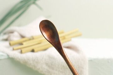 Eco bamboo spoon on green background. Concept, natural material organic cutlery, zero waste,...