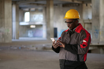 African american workman holds in hands smartphone and dials number