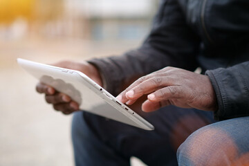 African american man works with tablet computer, close-up