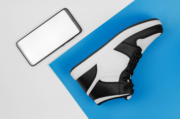 Sneaker and smartphone on blue white background