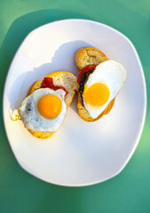 Typical spanish tapas with fried egg, chorizo and fried pepper.