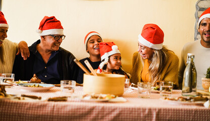 Happy latin family having fun eating together during Christmas time - Soft focus on grandfather face