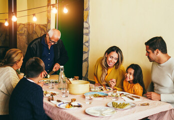 Happy latin family cooking together during dinner time at home - Focus on grandfather face
