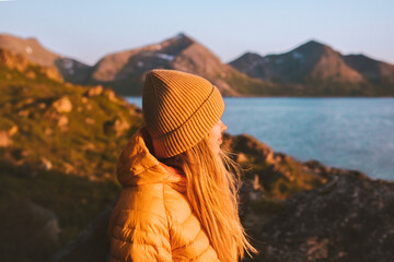 Woman traveling outdoor in Norway autumn season adventure trip active lifestyle sunset mountains and fjord landscape Kvaloya island