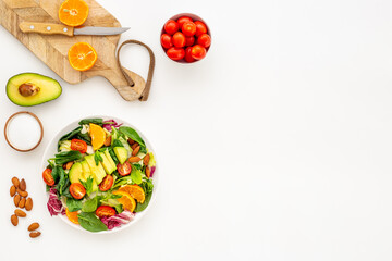 Top view of served green salad with avocado and tomatoes