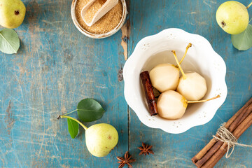white plate with delicious pears in wine on a wooden table.