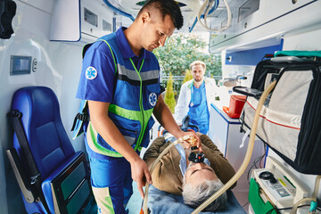 First aid, ambulance treatment. Ambulance care assistant providing medical help with artificial...