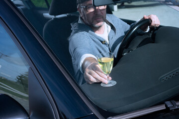 Obraz premium A man with a glass of wine driving a car.