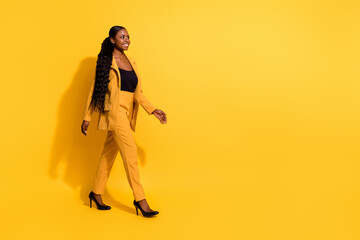 Full length body size view of attractive cheerful girl agent broker going copy blank space isolated on bright yellow color background