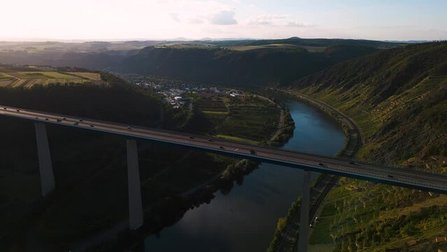 Moselle Viaduct, Winningen, Germany - aerial drone flyover the Moseltalbr&uuml;cke and highway A61 over the river Moselle valley, bridge connecting the Eifel mountains since 1972 sunset bird view ascending
