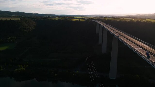 Ascending aerial drone flight along the Moseltalbr&uuml;cke and highway A61 over the river Moselle valley, bridge connecting the Eifel mountains since 1972 - sunset bird view shot - Viaduct in Germany