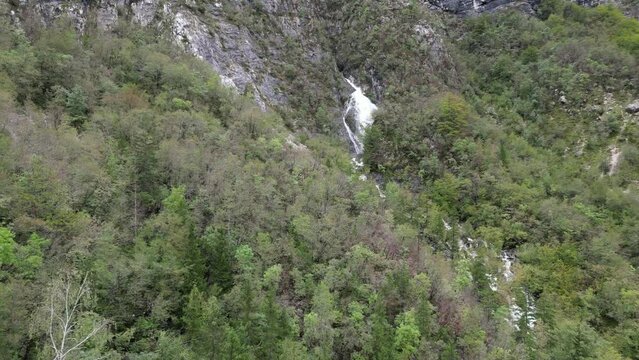 Waterfall cascading though trees Lake Bohinj Slovenia drone aerial view