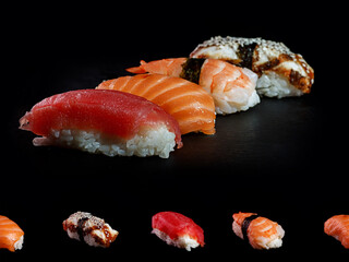 four types of nigiri sushi on a black background