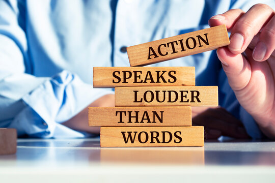 Wooden blocks with words 'Action Speaks Louder Than Words'.
