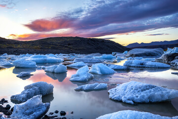 Sunset across the ice and mountains of Svinafellsjokul glacier lagoon at sunset., southern iceland. Part of the larger Vatnajokull glacier, the largest ice cap in iceland