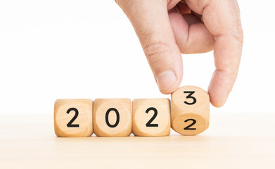 Hand changing Wooden Blocks with 2022 to 2023 year. Copy space