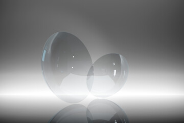 Pair of contact lenses, standing on a shiny studio floor. Digitally generated. Front view.