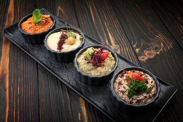 Oriental snacks, hummus on a black plate