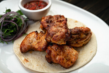 Shish kebab with barbecue sauce on a plate, with a small depth of field