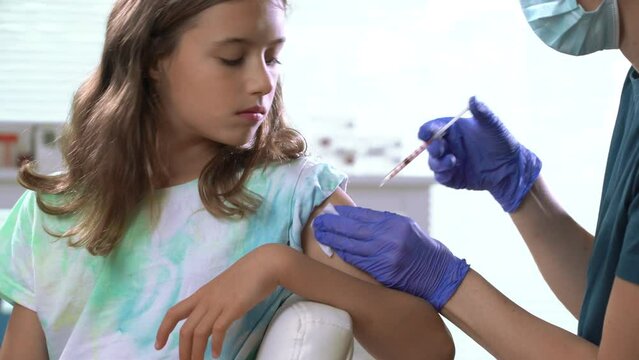 Female nurse doctor vaccinating child. Concept of vaccination program, children's vaccination, prevention of infectious diseases, anti-coronavirus vaccination