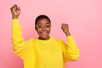 Fototapeta premium Photo of overjoyed delighted lady raise fists success achievement isolated on pink color background