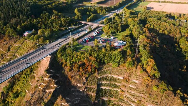 Aerial drone flyover the Mosel Valley West rest stop at Autobahn A61 over the river Moselle valley, bridge connecting the Eifel mountains since 1972 - bird view - Moselle Viaduct, Winningen, Germany