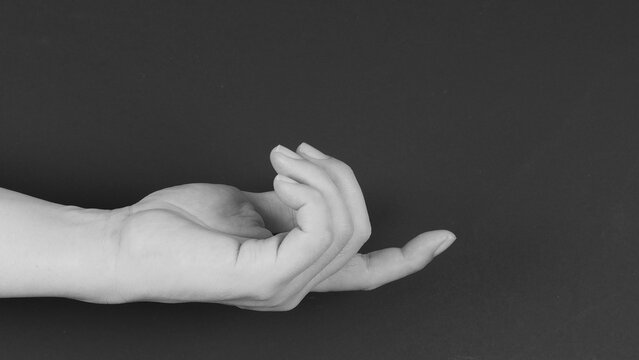 Index finger hand gesture on black background. Black and white picture