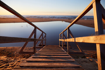 Wooden path ramp going into water, selective focus