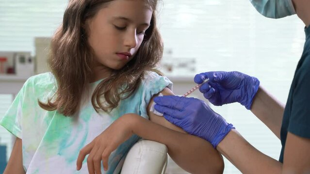 Female nurse doctor vaccinating child. Concept of vaccination program, children's vaccination, prevention of infectious diseases, anti-coronavirus vaccination