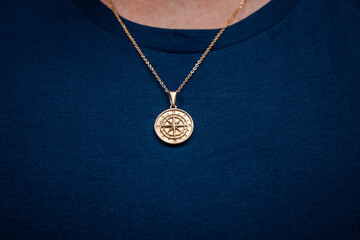 Fototapeta na wymiar Gold necklace on blue background jewelry fashion 