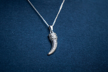Fototapeta na wymiar Silver necklace on blue background jewelry fashion 