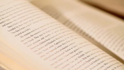 Close up view of open book with blurred pages at background.