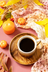 Autumnal breakfast. Composition fall leaves, hot cup of coffee and warm scarf. Cozy autumn season concept.