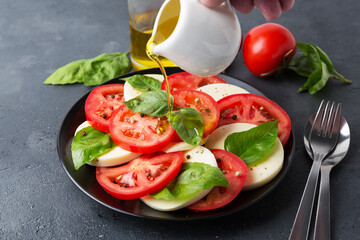 Caprese Salad with tomatoes and mozzarella with olive oil.