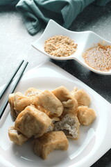 Fried tofu served in a white plate with tamarind sauce and mashed beans, fried tofu is a popular dish among Chinese and Asians.