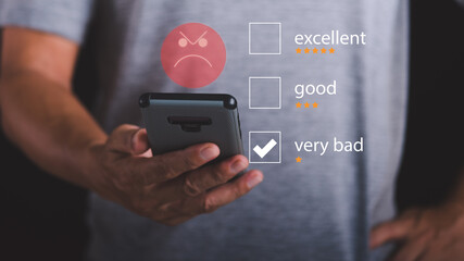 Male consumers use smartphones to express dissatisfaction after receiving a product or service, negative rating concept from a business or product, online rating..