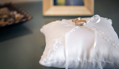 Stacking wedding rings placed on top of a white pillow