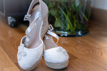 Close-up of elegant white embroidered wedding shoes