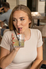 Beautiful young woman drinking cocktail