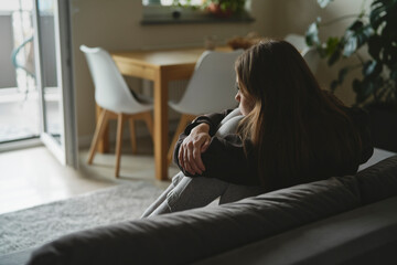 Obraz premium Caucasian sad woman sitting at the sofa with depression