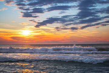 Beautiful sunrise over the sea water and beach