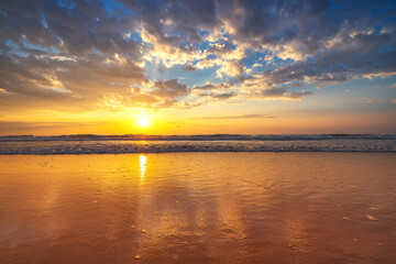 Beautiful sunrise over the sea waves and beach